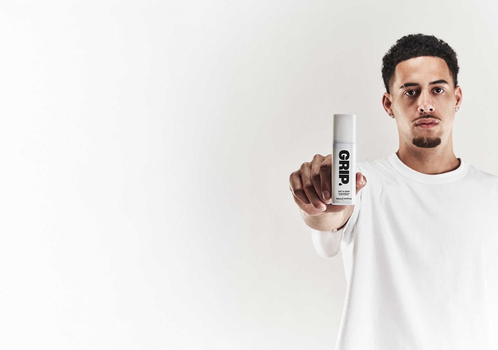 Man holding a bottle labeled 'Grip' against a white background